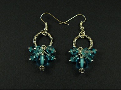 Boucle d'oreille fantaisie composée de perles de verre bleues transparentes et d'un grand anneau